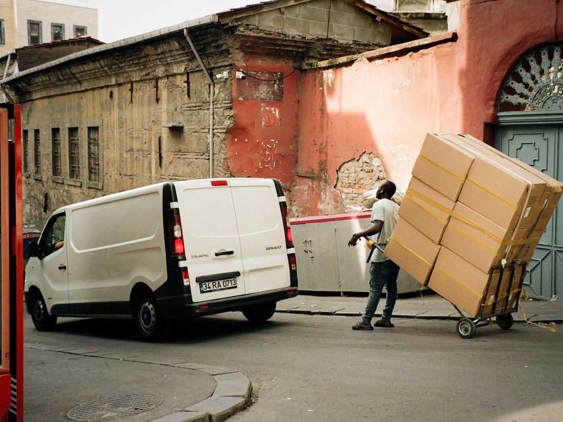 A mover unloading stacked boxes from a van